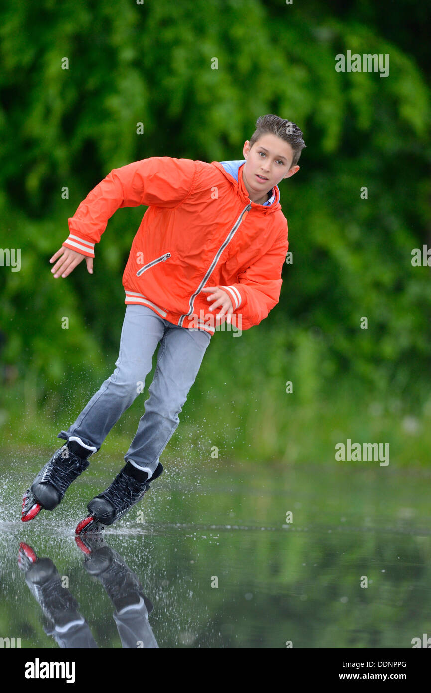 Garçon avec des patins à roues alignées sur un jour de pluie Banque D'Images