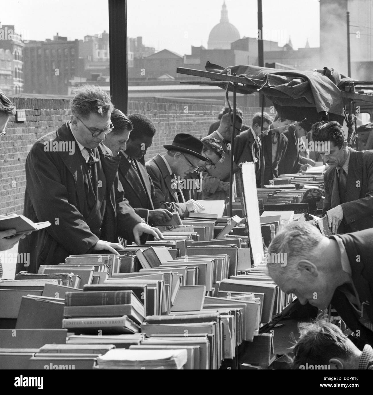 Une rangée d'hommes parcourir une libraire d'occasion, de décrochage de Londres, Finsbury, c1946-c1959. Artiste : John Gay Banque D'Images