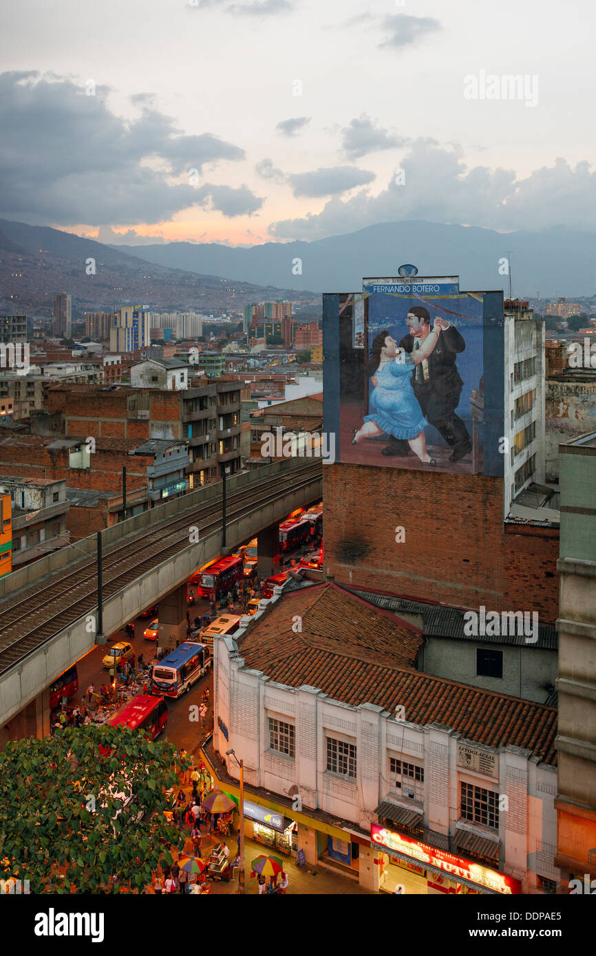 Centre de Medellin en fin de soirée avec une ad de Fernando Botero sur le mur de la maison. Banque D'Images