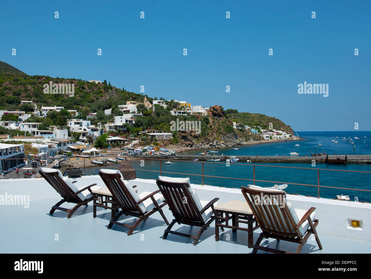 Chaises longues donnant sur San Pietro sur l'île de Panarea dans les îles Eoliennes, Messine, Sicile, Italie Banque D'Images