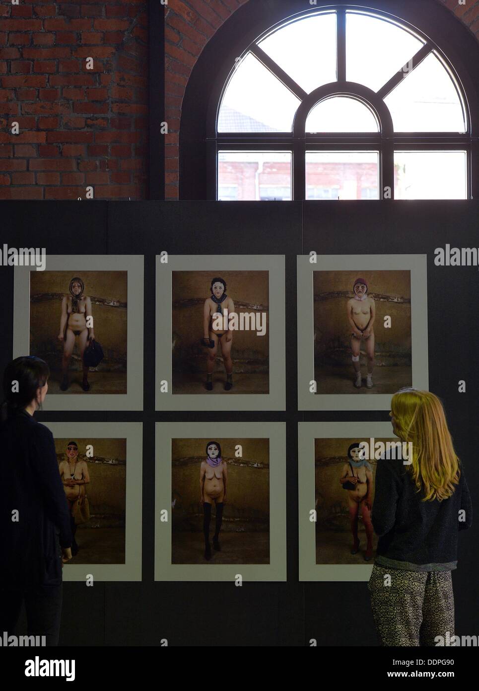 Les gens regardent à partir de photographies de la série "Le beau visage" par l'artiste coréen Yi Ongiong au Musée de l'industrie à Chemnitz, Allemagne, 05 septembre 2013. Plus de 300 artistes provenant de 20 pays présentent leurs travaux dans le cadre de la concurrence Marianne Brandt pour la conception du produit et de la photographie à partir du 07 septembre 2013. Les œuvres seront exposées dans des endroits comme Tokyo, Oslo, Berlin et Moscou en 2014. Photo : HENDRIK SCHMIDT Banque D'Images