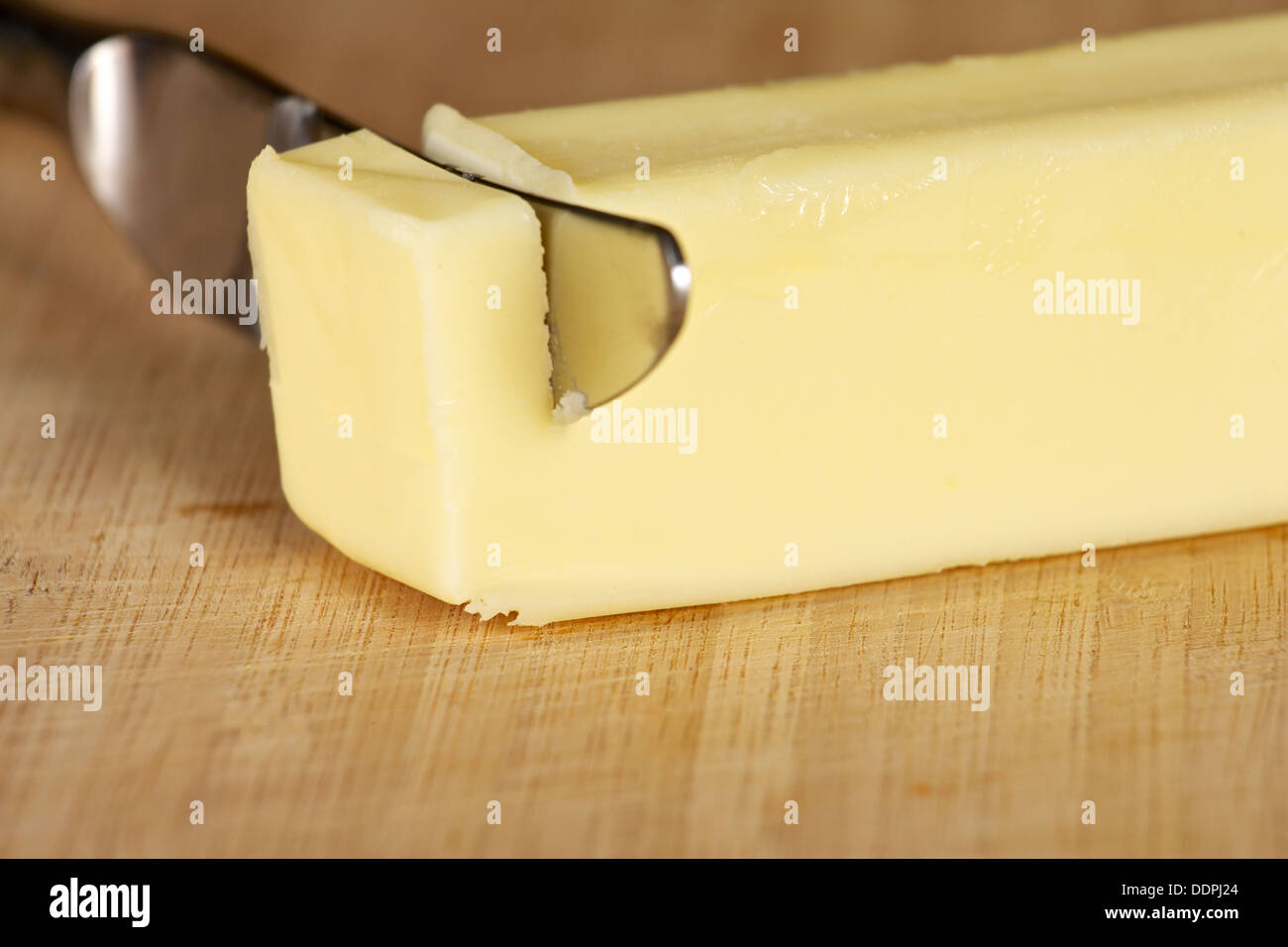 Stick de beurre de table sur une planche à découper avec couteau Banque D'Images