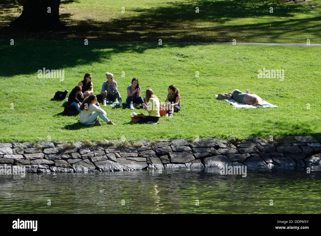 Les filles ont un pique-nique sur la berge, dans un parc, Göteborg, Suède Banque D'Images