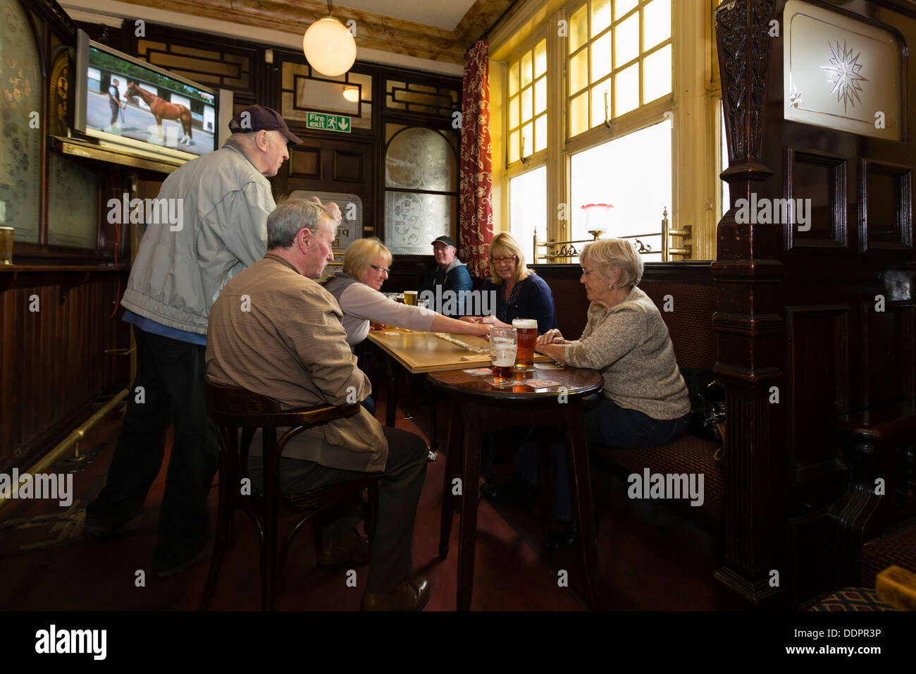 Deux hommes et deux femmes jouant aux dominos dans le pub à Leeds Cardigan Arms Banque D'Images