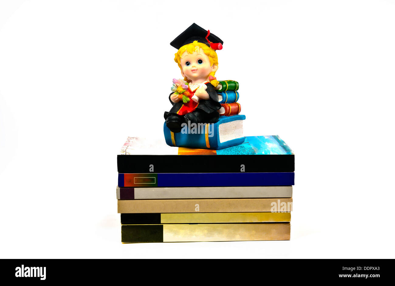 L'obtention du diplôme et poupée en résine livres sur fond blanc Banque D'Images