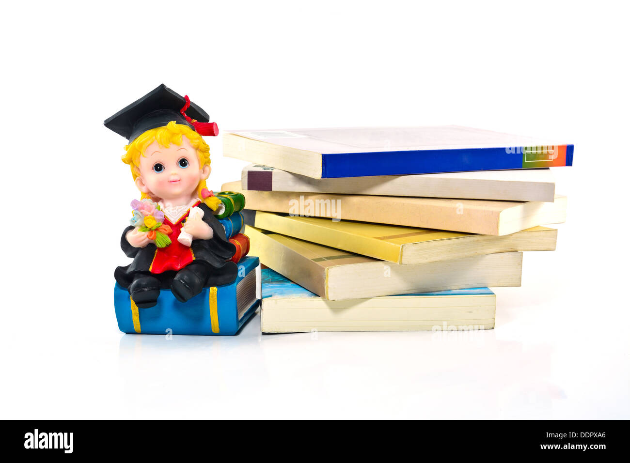 L'obtention du diplôme et poupée en résine livres sur fond blanc Banque D'Images