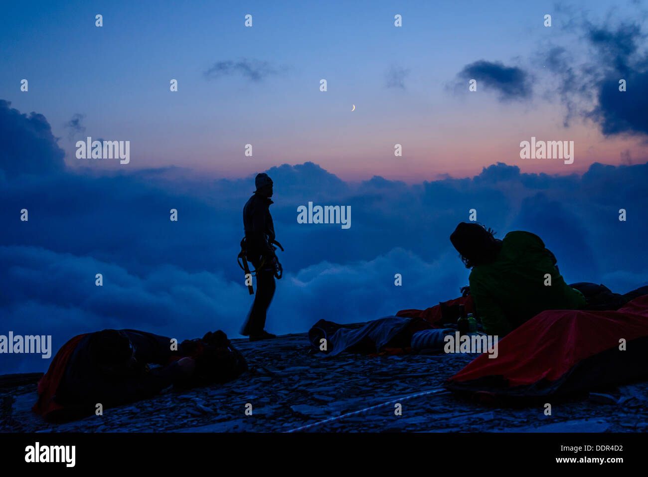 Les alpinistes avant l'aube lors d'un bivouac sur le sommet de la Rotstock au dessus de Grindelwald Suisse Banque D'Images