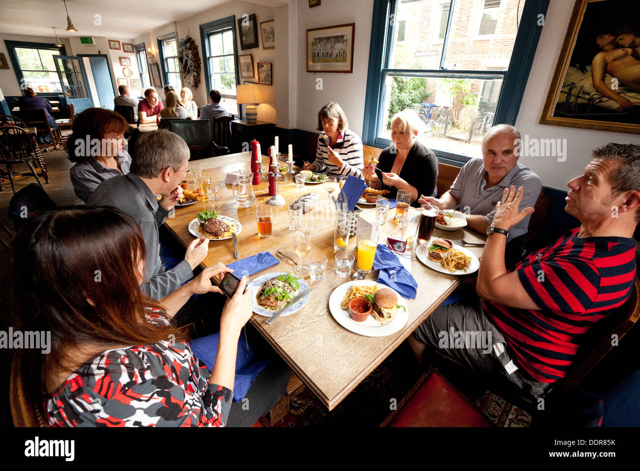 Groupe de personnes ayant un repas dans un pub, le parieur Pub, South St, Oxford, Oxfordshire, UK Banque D'Images
