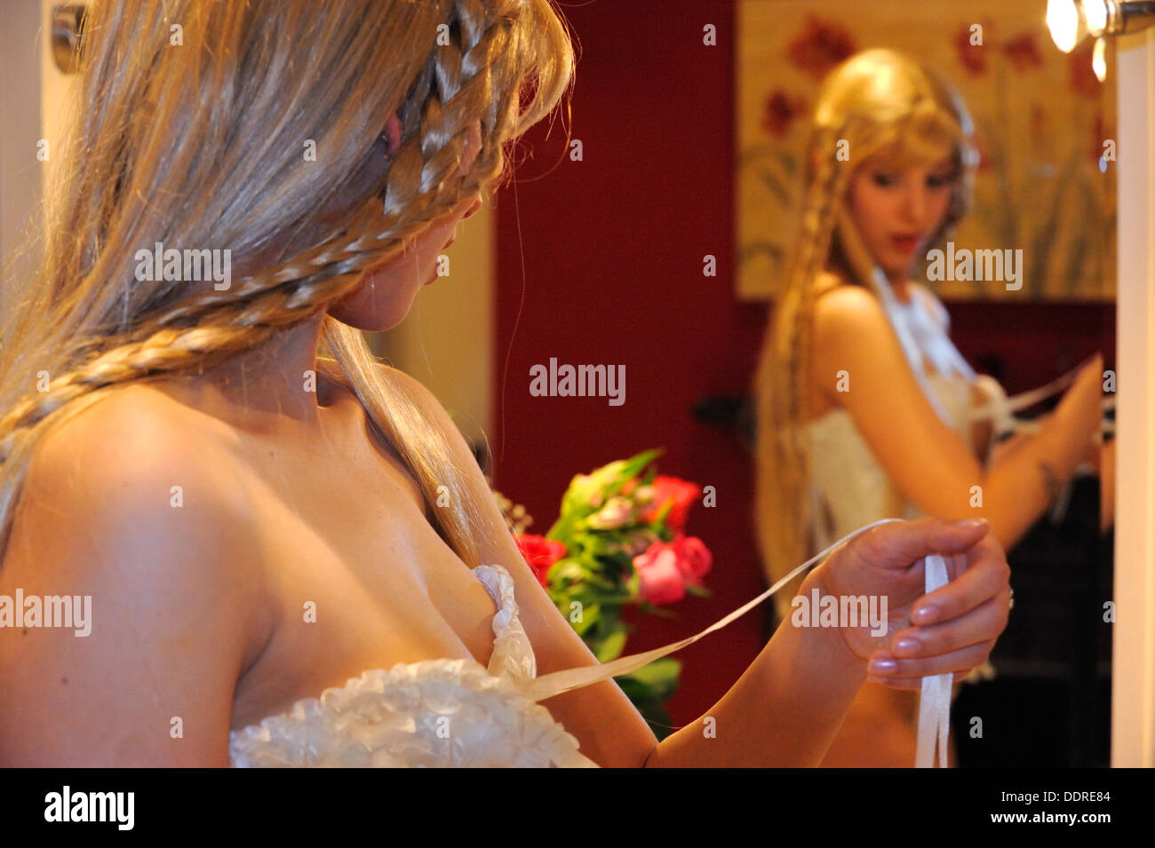 Une jeune femme la modélisation d'un corset blanc dans sa suite nuptiale Banque D'Images