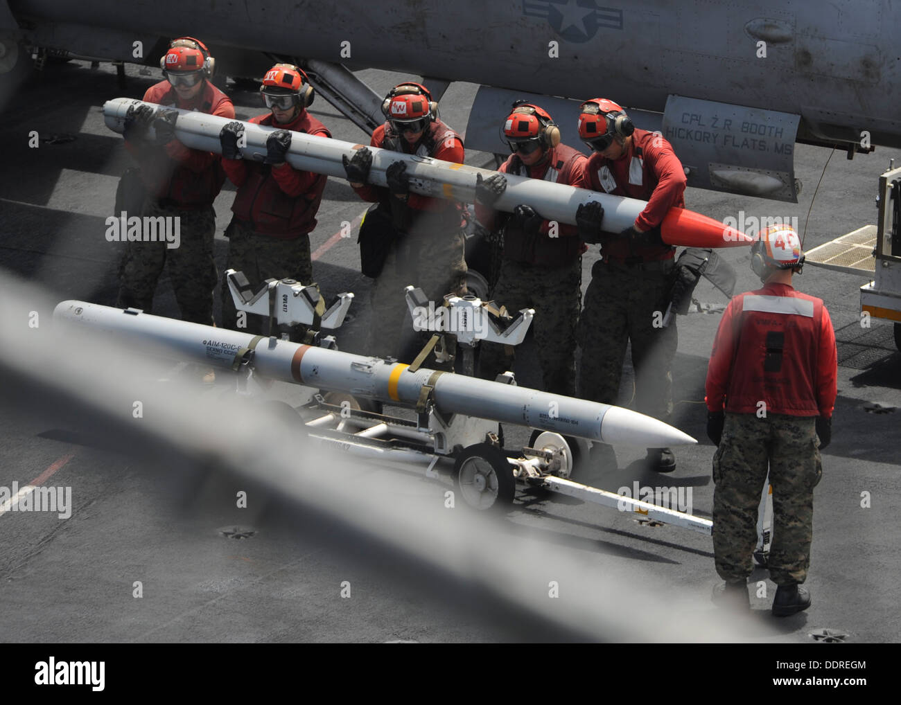 Ordnancemen Aviation affectés à la mort de Marine Rattlers Fighter Attack Squadron (VMFA) 323 ascenseur un missile sur le pont du porte-avions USS Nimitz (CVN 68). Le groupe aéronaval du Nimitz est déployée sur l'espace de 5e flotte américaine respo Banque D'Images