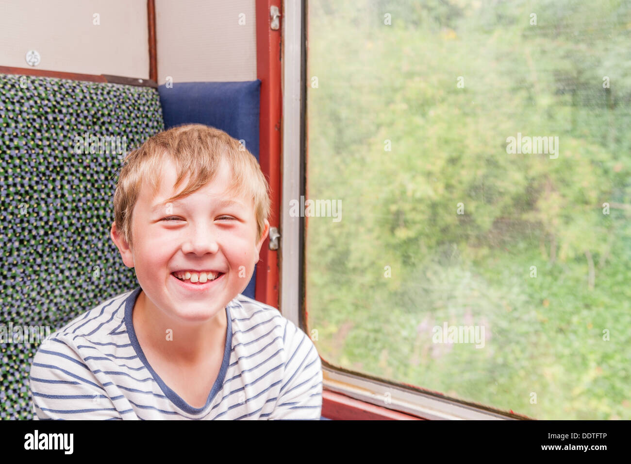 Un heureux 9 ans dans un train Banque D'Images