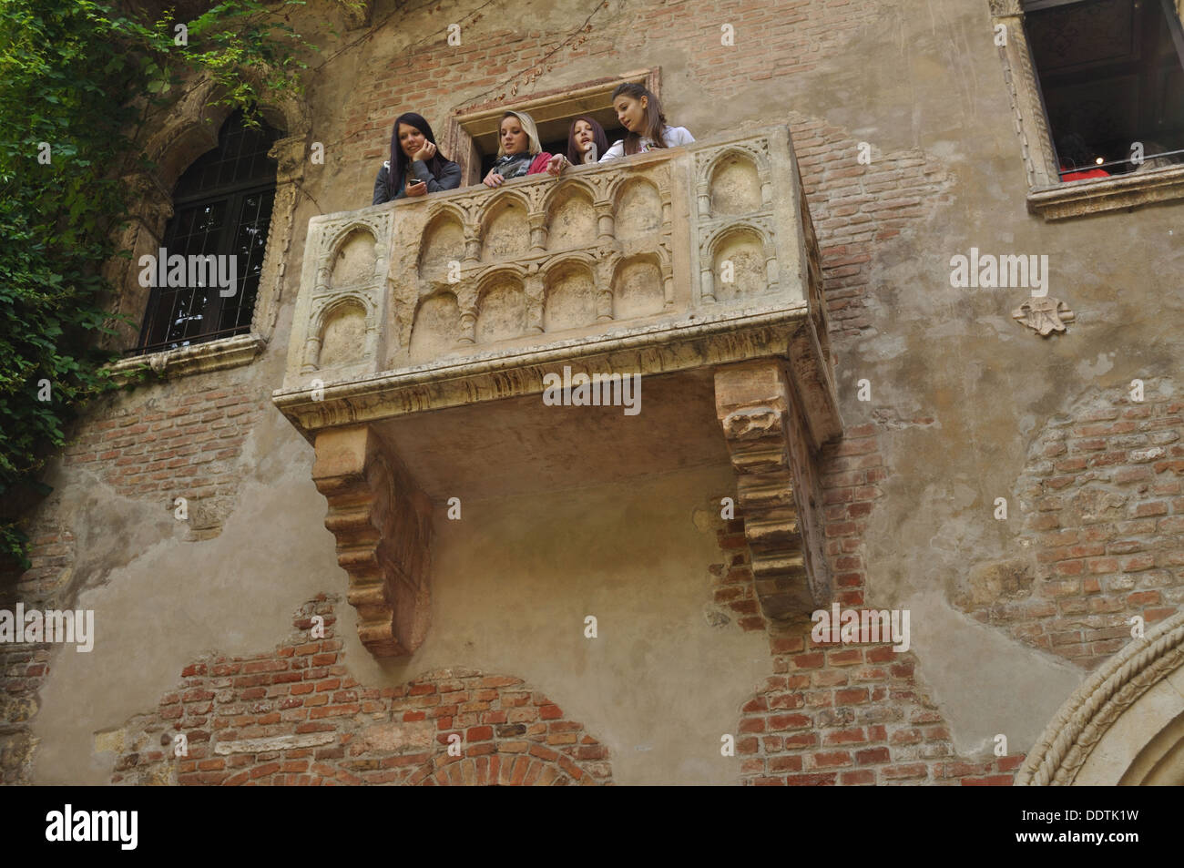 Quatre jeunes les Juliets regarder dehors de son balcon dans la Casa di Giulietta, Vérone. Banque D'Images