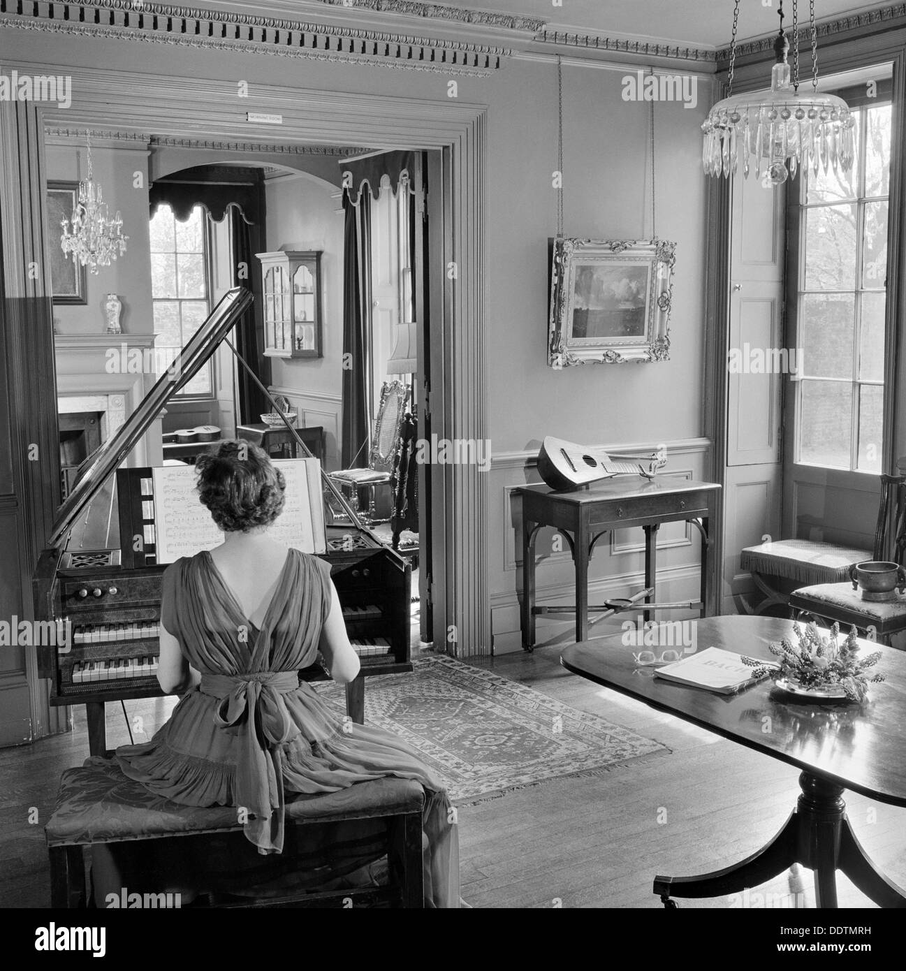 Femme en robe de soirée à jouer du clavecin, Fenton House, Londres, 1960-1965. Artiste : John Gay Banque D'Images