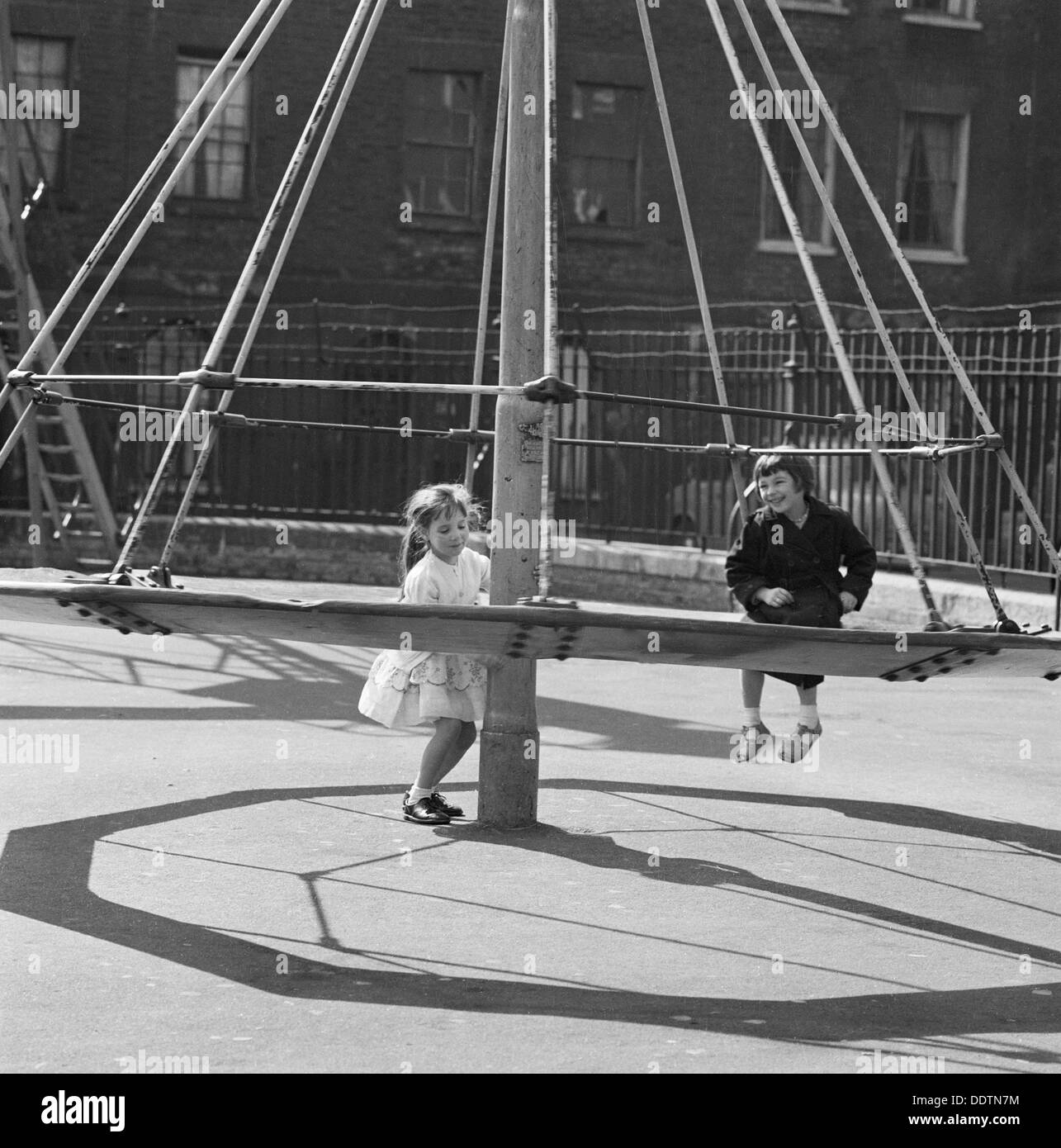 Les filles jouant sur un 'witch's hat' dans une aire de jeux, Londres, 1960-1965. Artiste : John Gay Banque D'Images