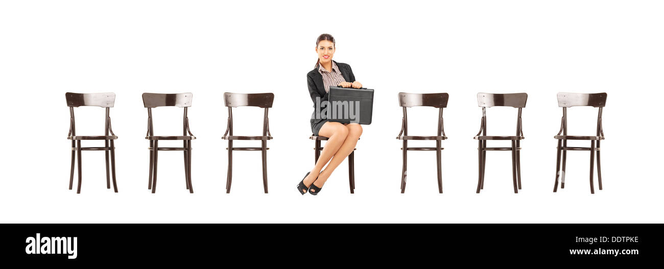 Pretty woman une serviette en cuir et en attente d'entrevue d'emploi sur une chaise en bois Banque D'Images