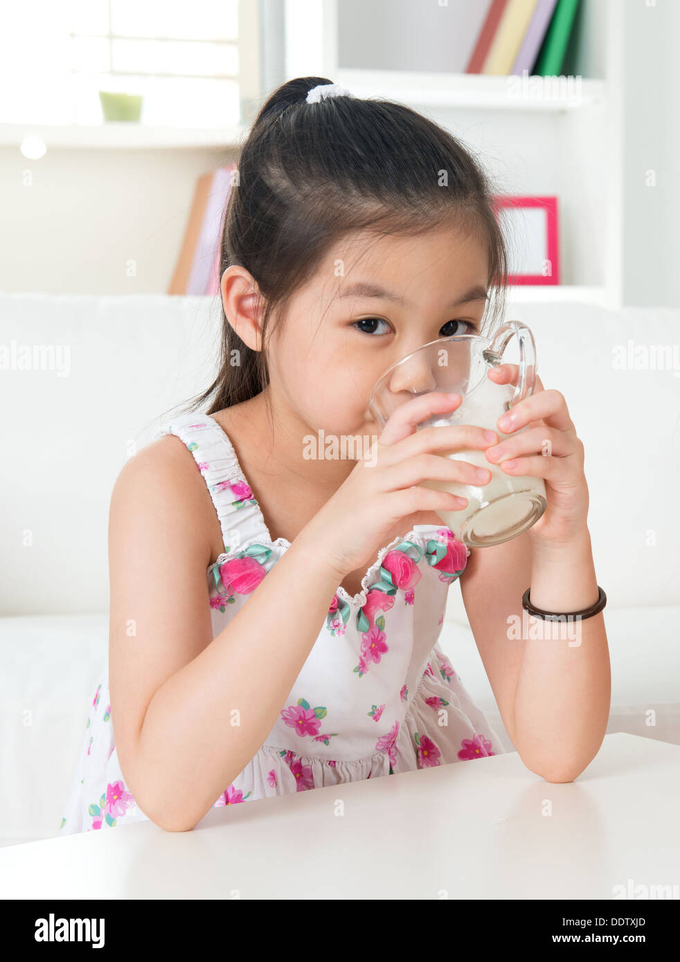 Le lait de consommation. Happy Asian kid boire du lait à la maison. Belle enfant. Concept de soins de santé. Banque D'Images