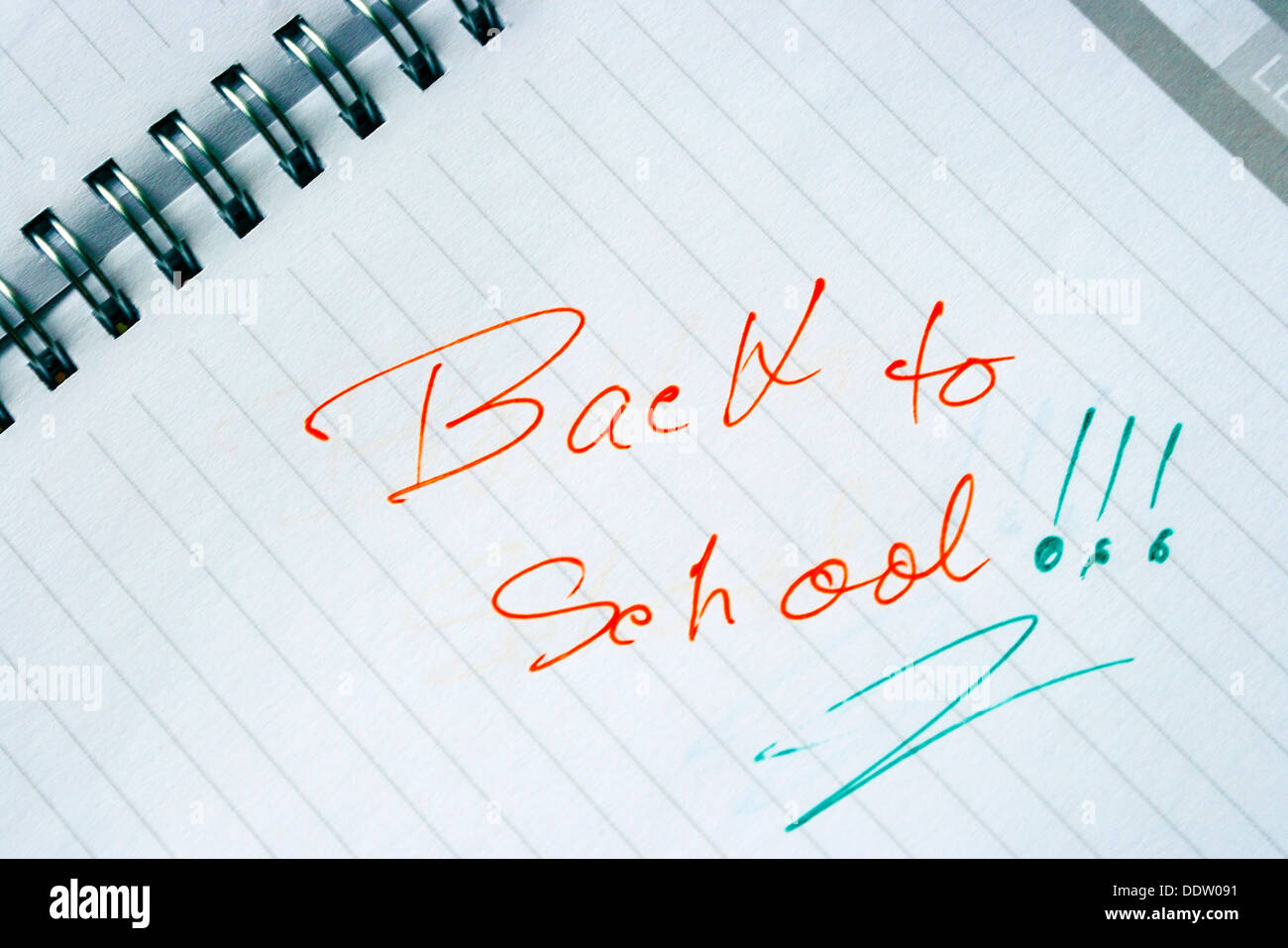 Ordinateur portable avec spirale métallique et est ouverte à l'une page qui dit ,,retour à l'école ' en orange et vert. Banque D'Images