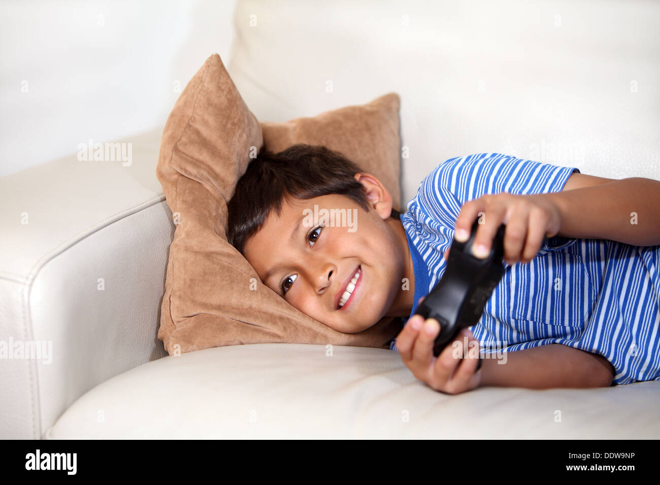 Jeune garçon à jouer à jeu en relxing sur le canapé Banque D'Images