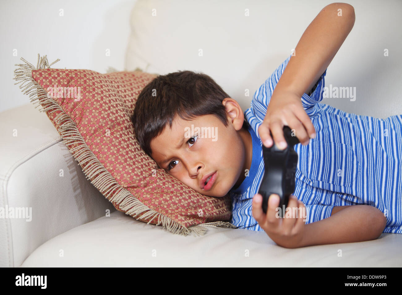 Jeune garçon à jouer à jeu en relxing sur le canapé Banque D'Images