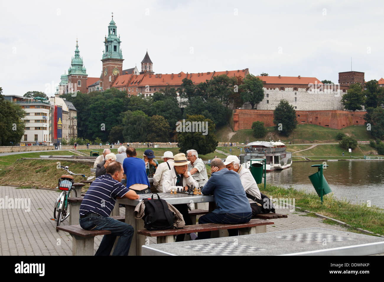 De vieux hommes jouant aux échecs à l'extérieur. Le château de Wawel du Roi dans l'arrière-plan. Cracovie, Pologne. Banque D'Images