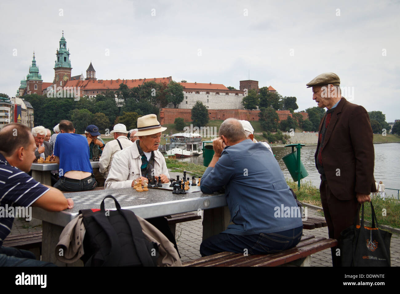 De vieux hommes jouant aux échecs à l'extérieur. Le château de Wawel du Roi dans l'arrière-plan. Cracovie, Pologne. Banque D'Images
