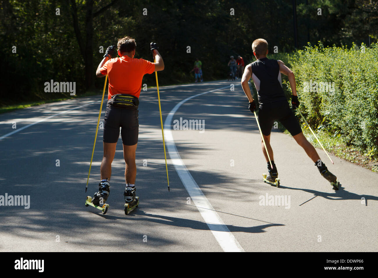 Deux jeune homme pratiquer ski à roulettes dans le parc (comme un équivalent de l'été le ski de fond). Katowice, Pologne. Banque D'Images