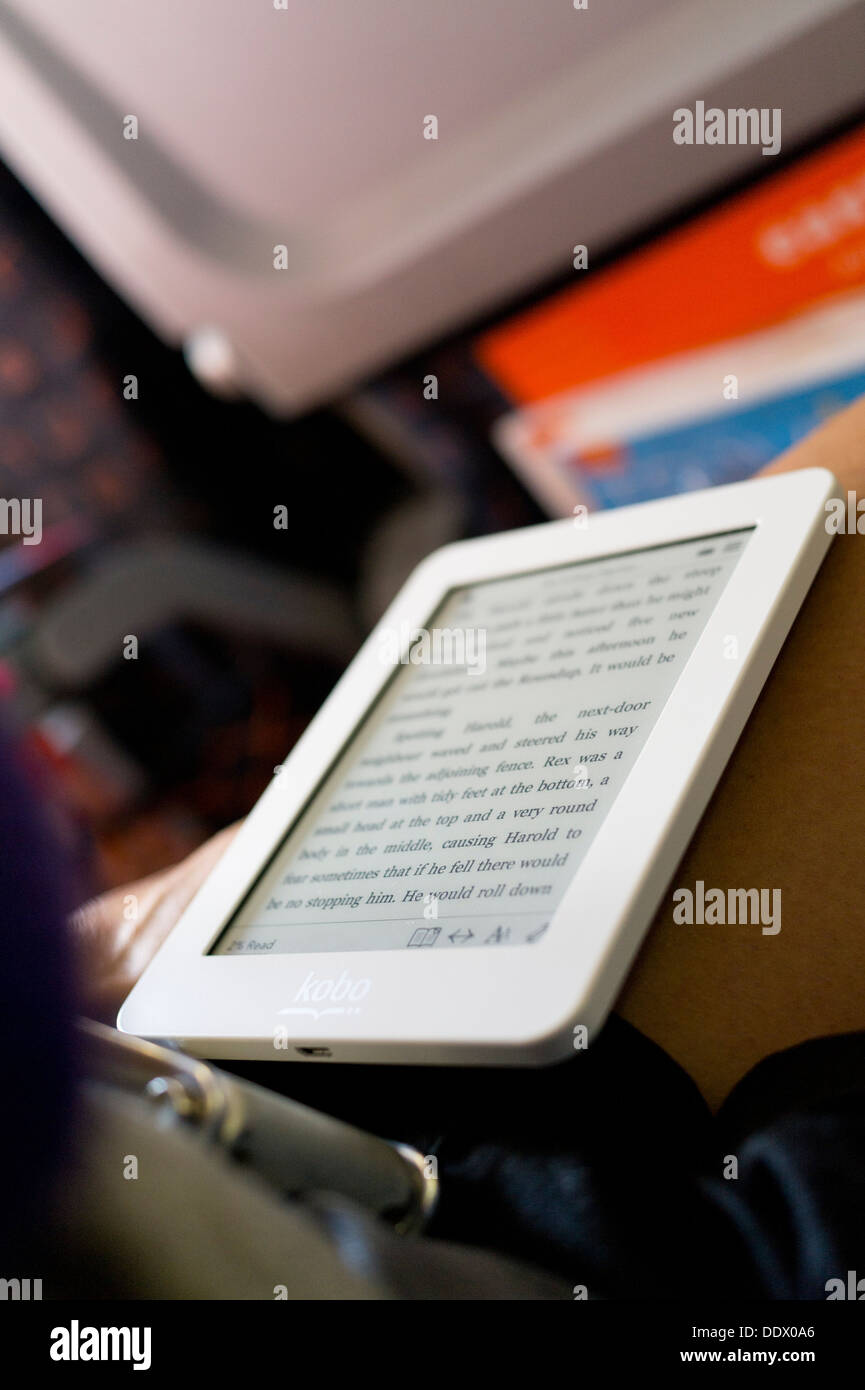 Voyageur passager dans les avions de la lecture du livre électronique ereader siège sur un vol. Banque D'Images