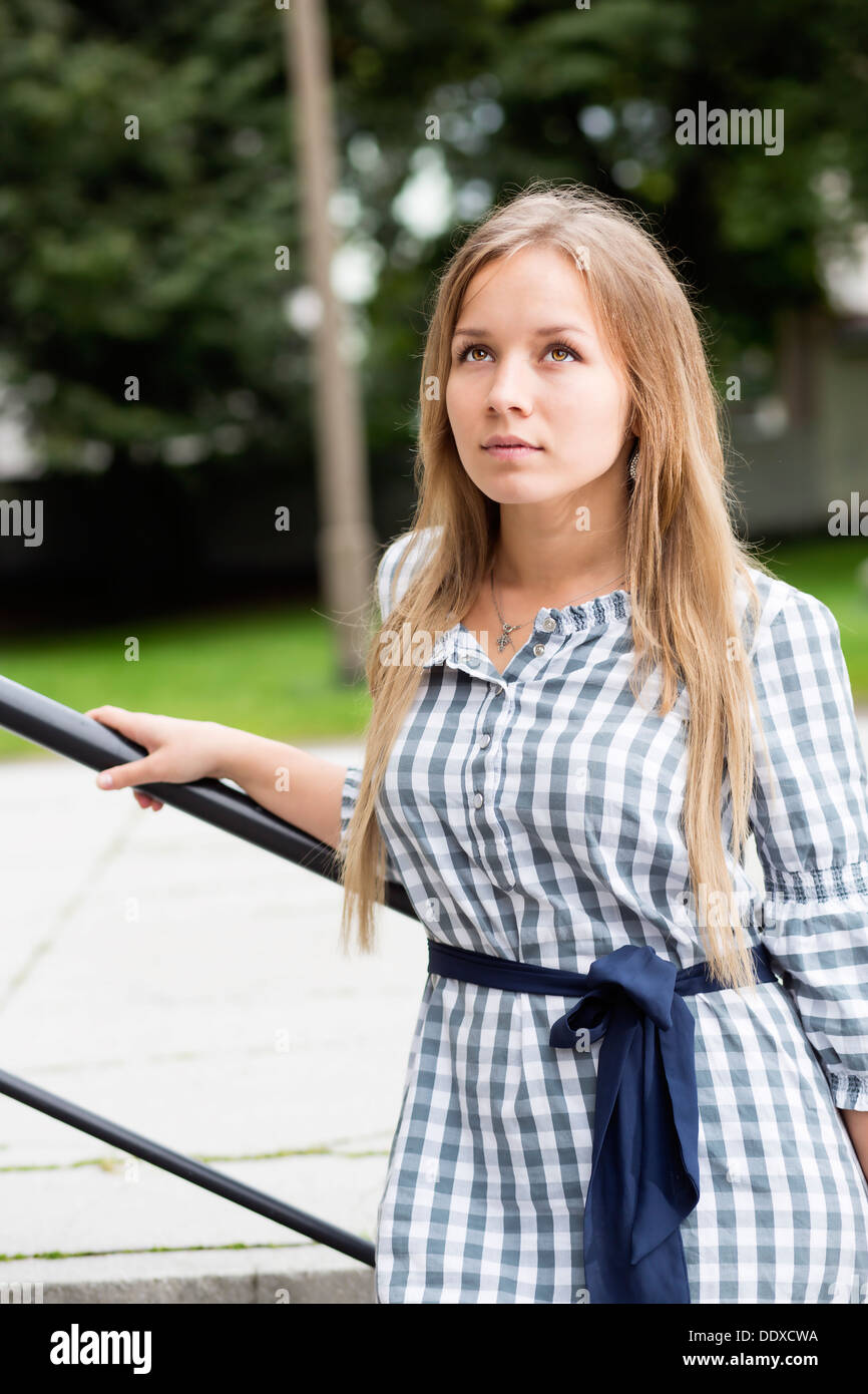 Femme en robe à carreaux avec bande bleu liée Banque D'Images