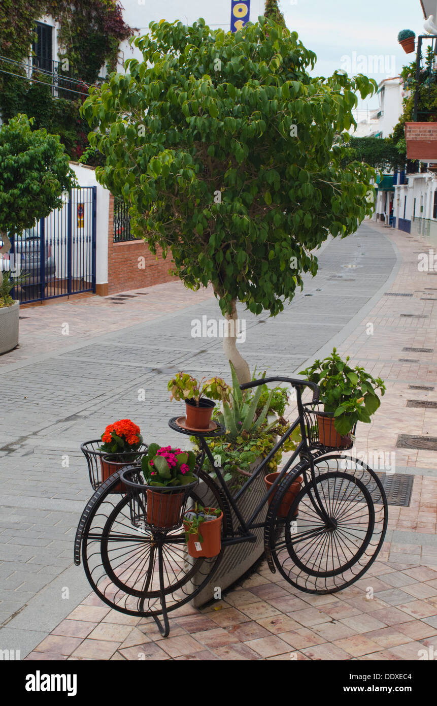 Vélo d'ornement pour contenant des plantes dans rue calme de Nerja, dans le sud de l'Espagne Banque D'Images