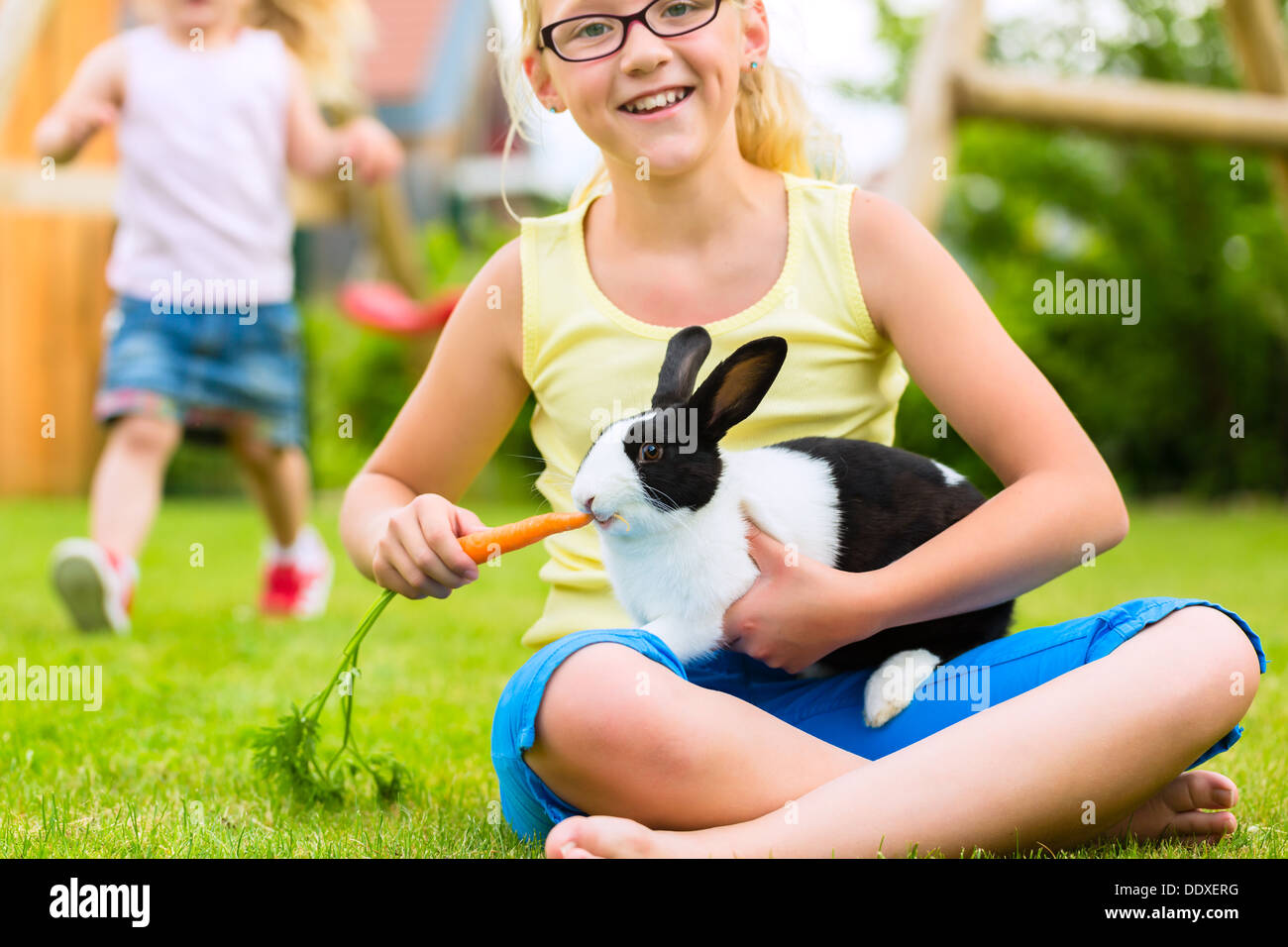 Happy Girl ou la fille avec son lapin ou bunny pet à la maison dans le jardin Banque D'Images