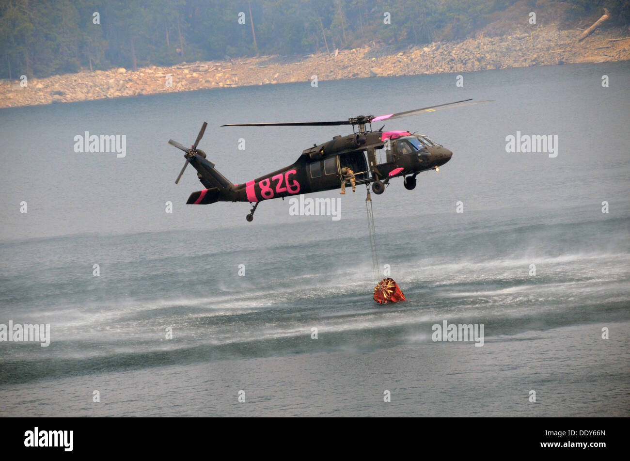 Un hélicoptère Black Hawk de l'armée américaine s'approche du barrage du lac de cerise pour remplir un seau d'hélicoptère à l'appui de la Rim Fire pendant l'incendie le 29 août 2013 près de Yosemite, CA. Banque D'Images