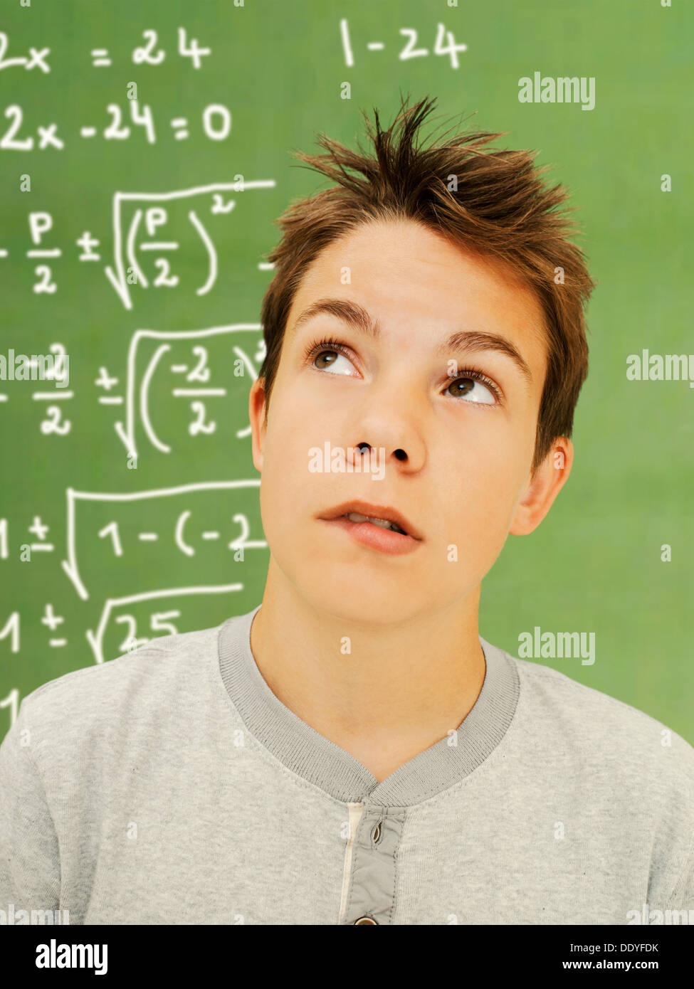 Portrait, écolier, adolescent, avec un air pensif devant une école tableau avec une équation mathématique Banque D'Images