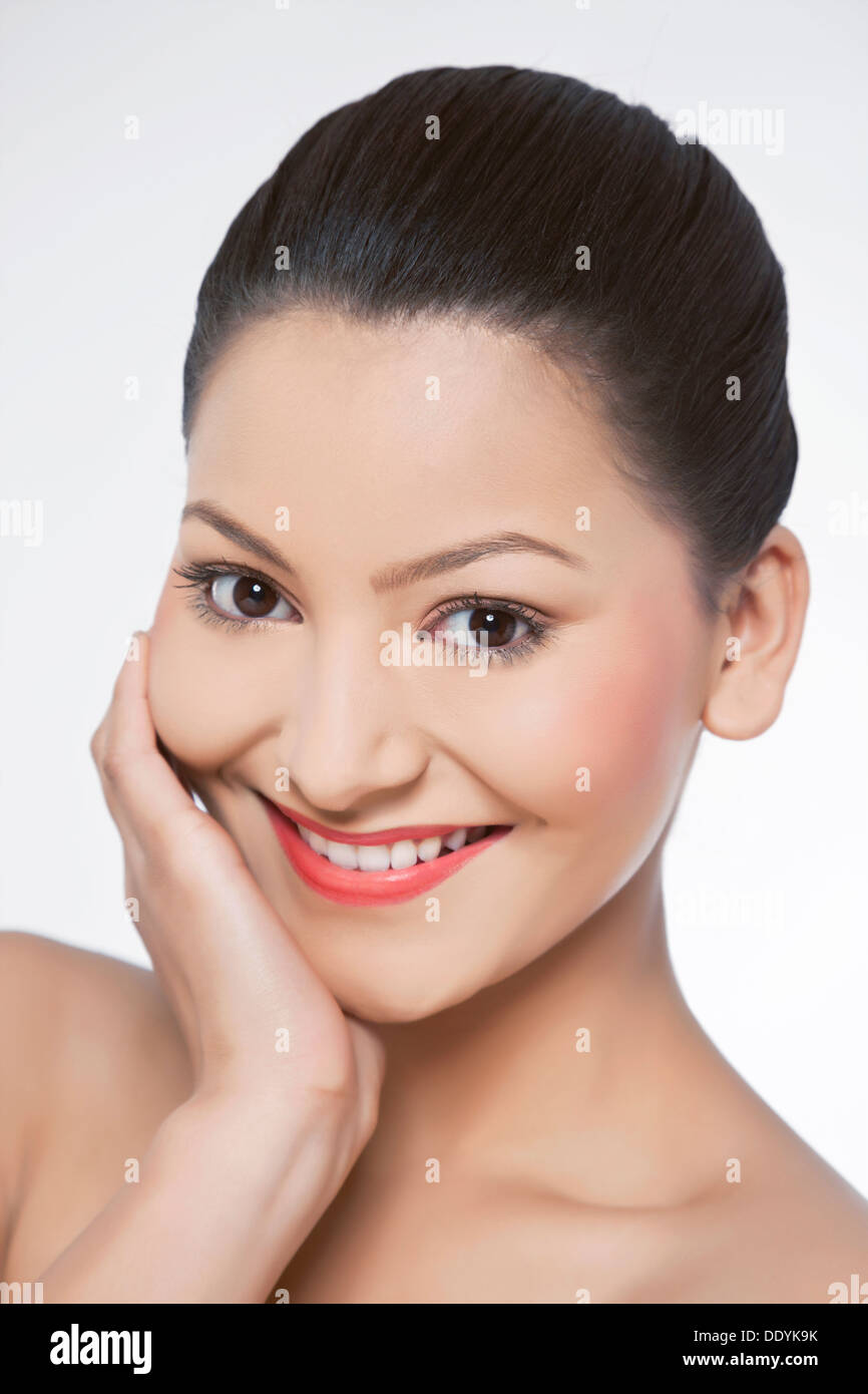 Young woman touching her face over white background Banque D'Images