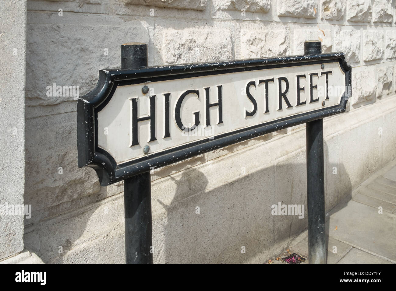 Un panneau routier de la rue en face d'un mur blanc Banque D'Images