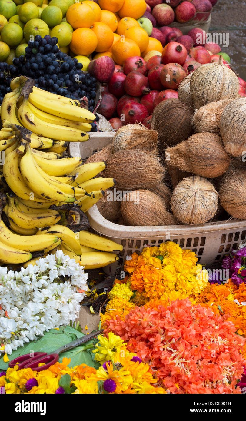 Les fruits, les fleurs et les noix de coco pour la vente dans une rue. L'Andhra Pradesh, Inde Banque D'Images