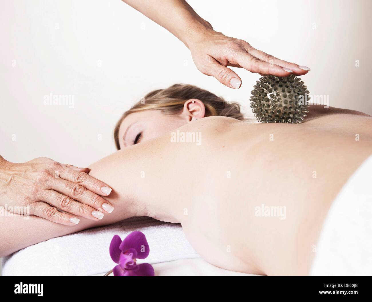 Jeune femme massée sur le dos avec une balle de massage en caoutchouc spikey Banque D'Images