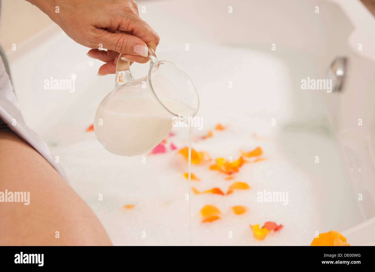 Woman pouring dans un bain de lait Banque D'Images