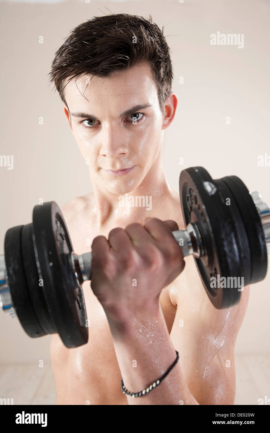 Jeune homme faisant la formation de poids avec haltères Banque D'Images