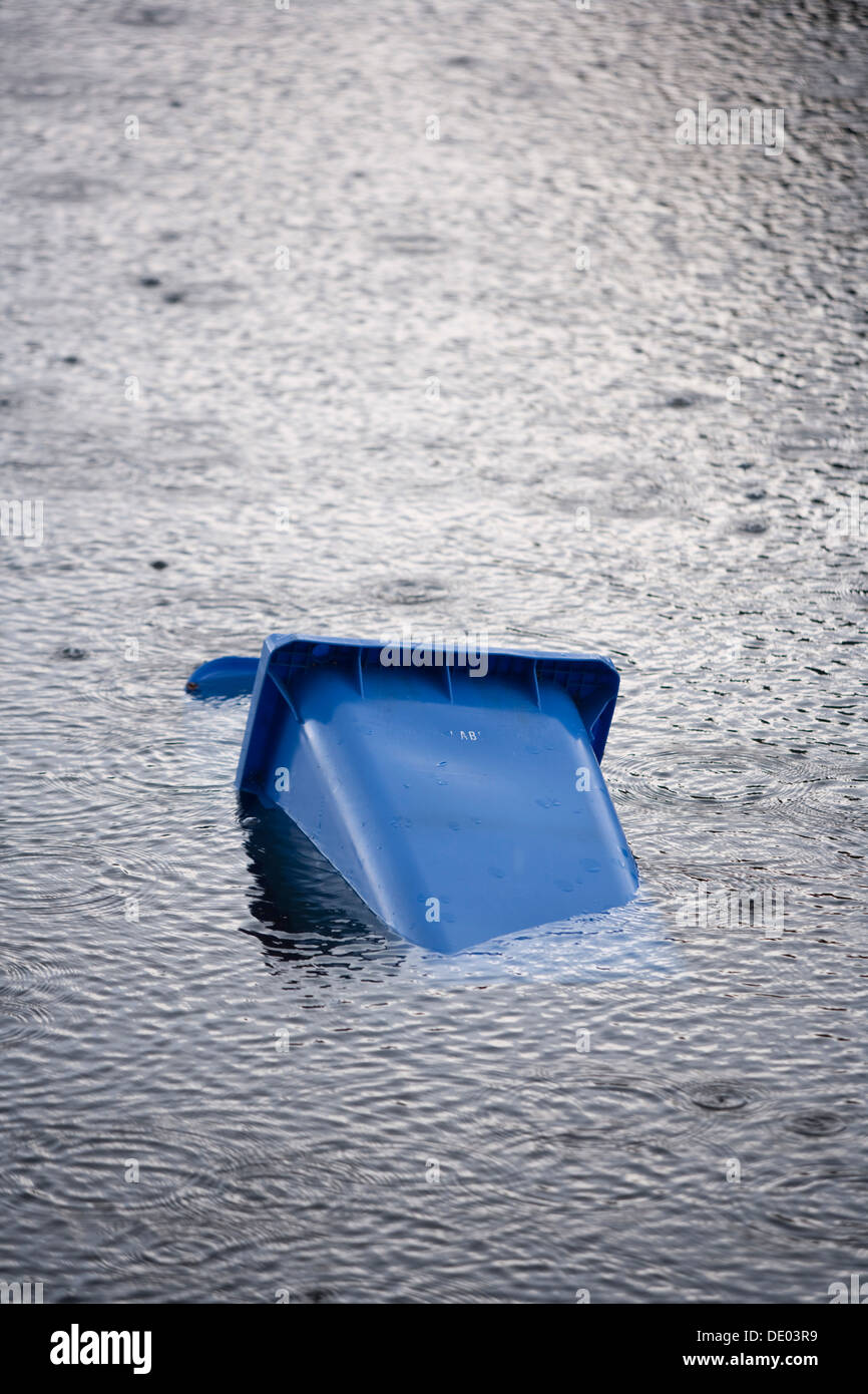 Bac de recyclage bleu flottant dans l'eau. Banque D'Images