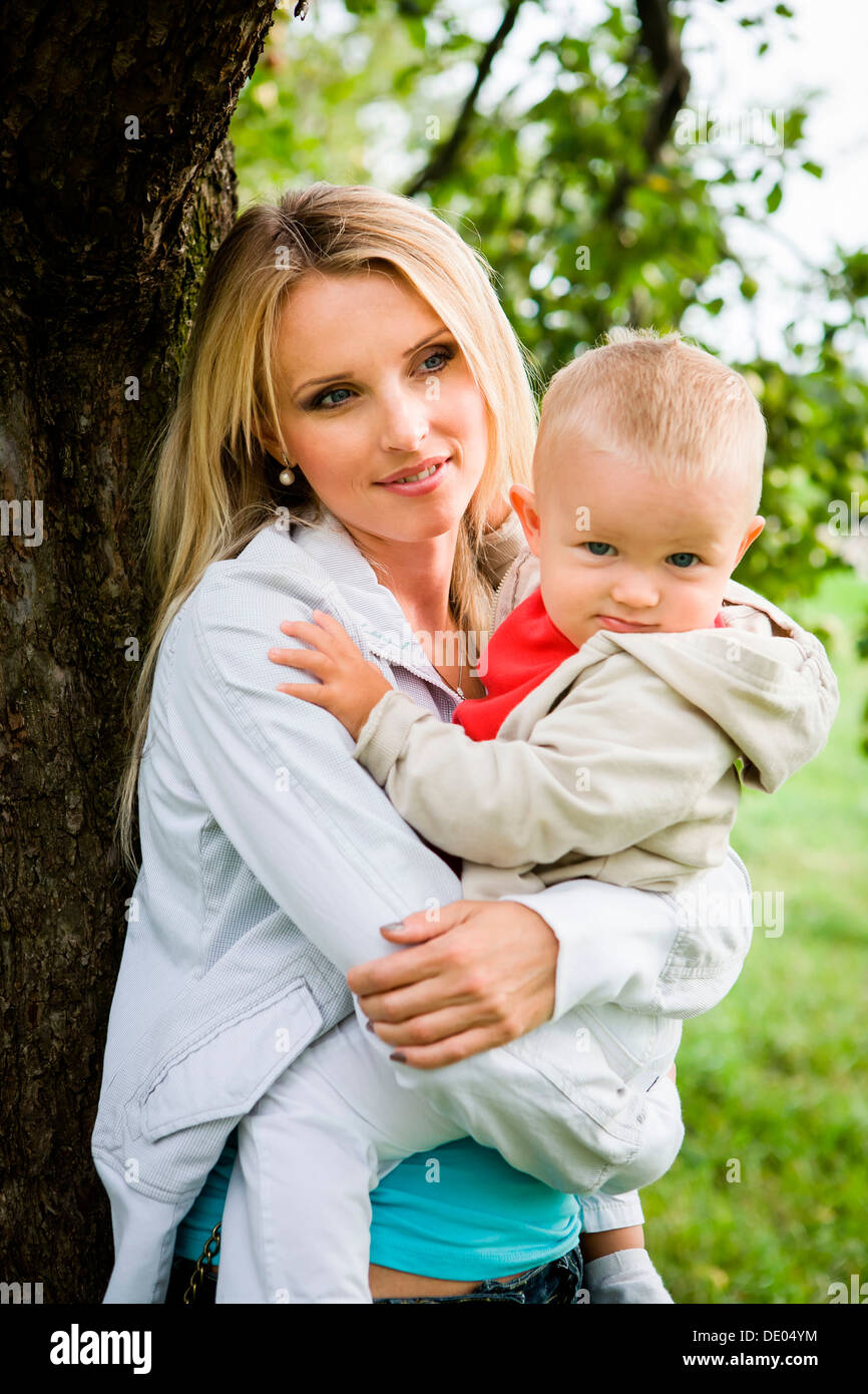 Jeune femme avec un enfant dans le jardin d'apple Banque D'Images