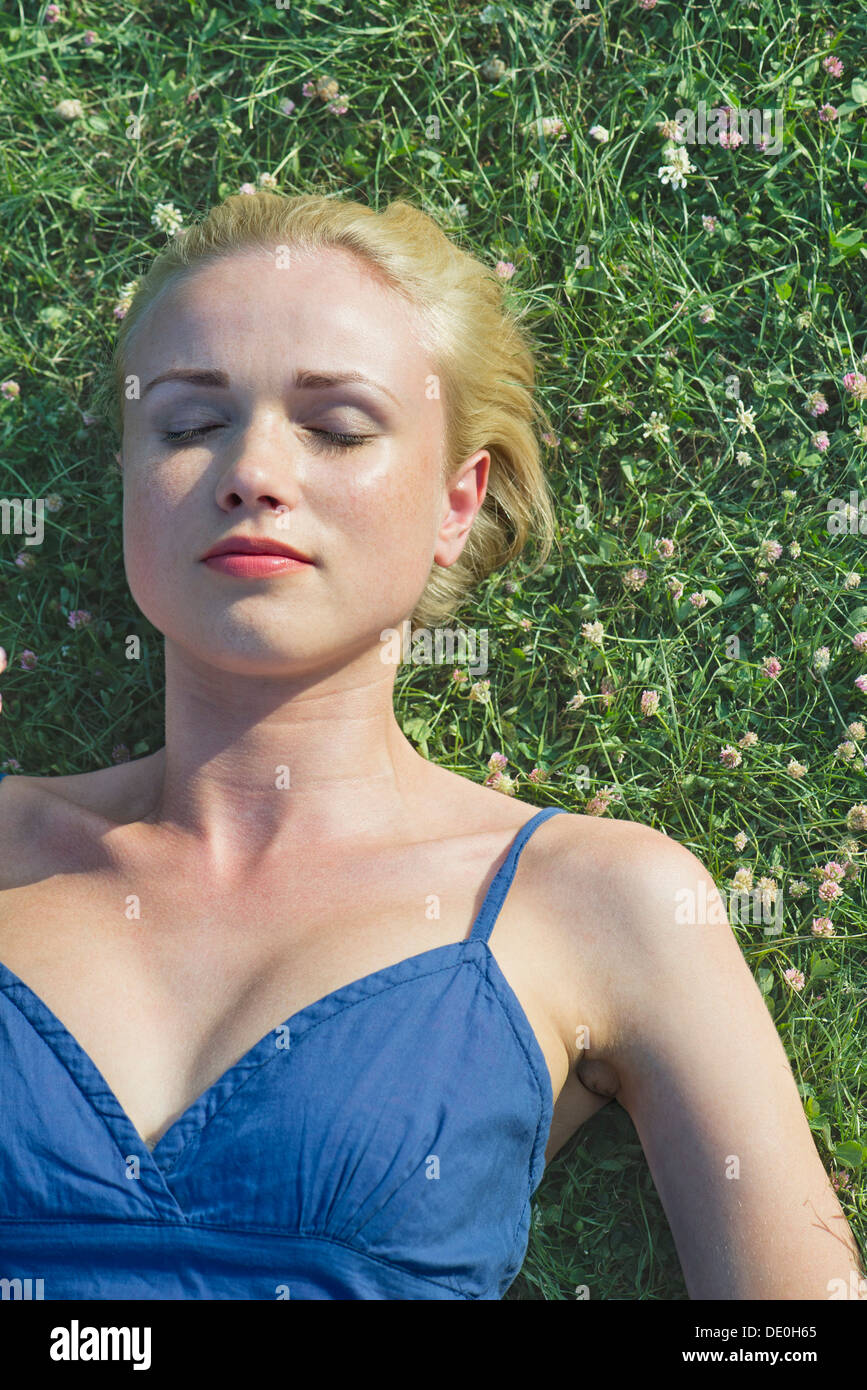 Jeune femme sieste sur l'herbe, portrait Banque D'Images