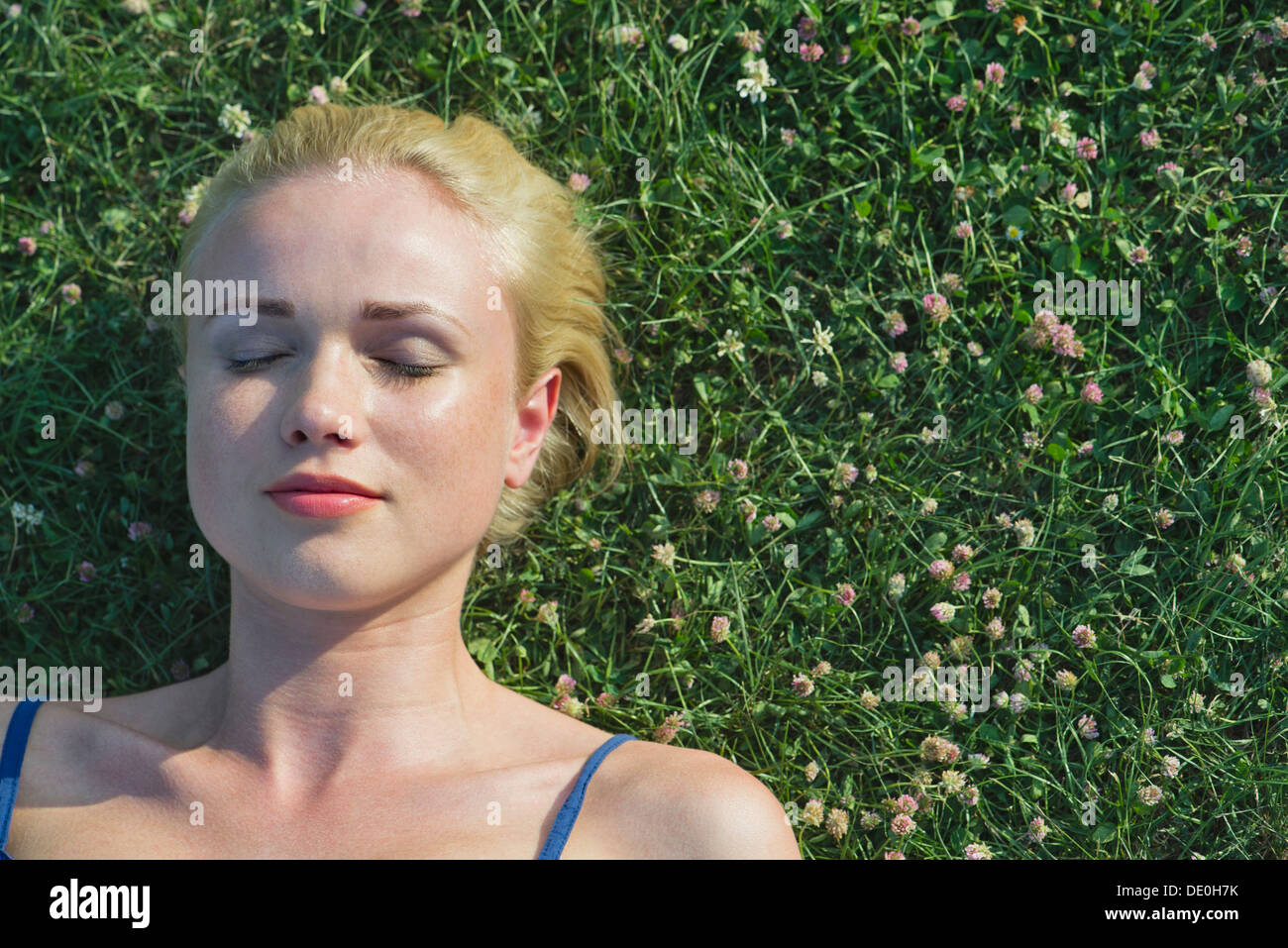 Jeune femme sieste sur l'herbe, portrait Banque D'Images