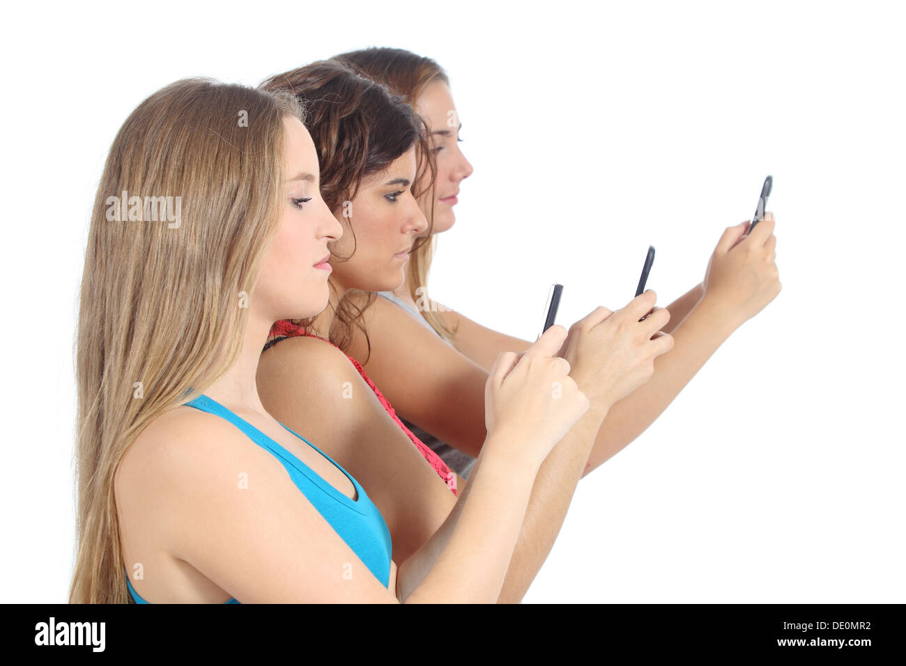 Groupe d'adolescentes obsédé par le téléphone intelligent isolé sur fond blanc Banque D'Images