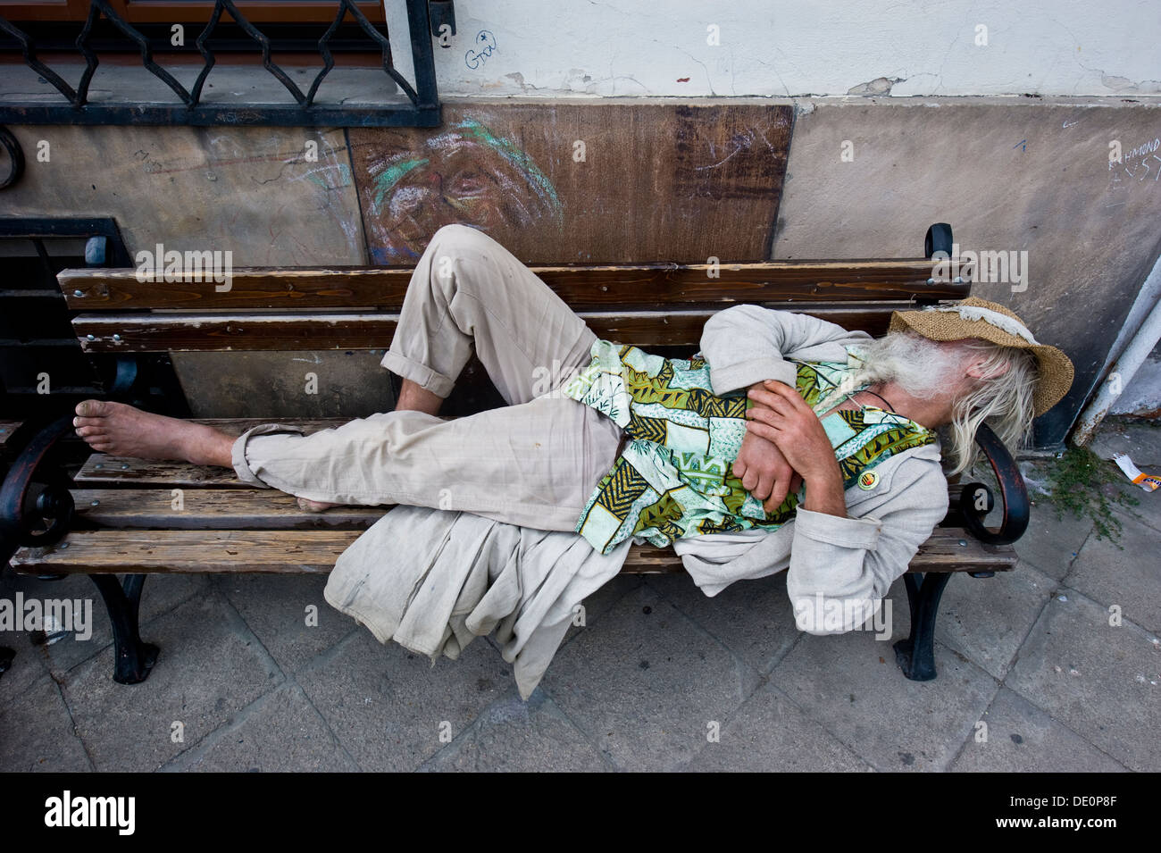 Un vagabond dormant sur un banc à Kazimierz Dolny. Banque D'Images