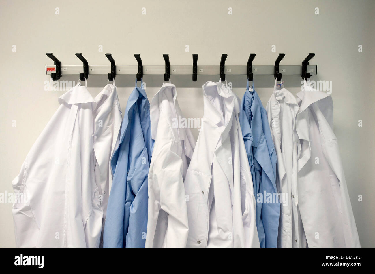 Les vêtements de travail, blouses de laboratoire blanc et bleu sur patère, laboratoire de chimie Banque D'Images