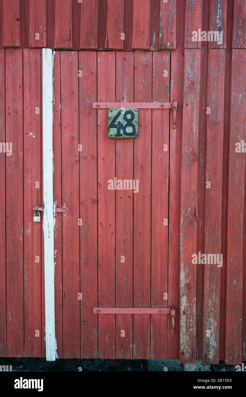Porte en bois rouge avec un cadenas et un panneau en bois, numéro 48 Banque D'Images