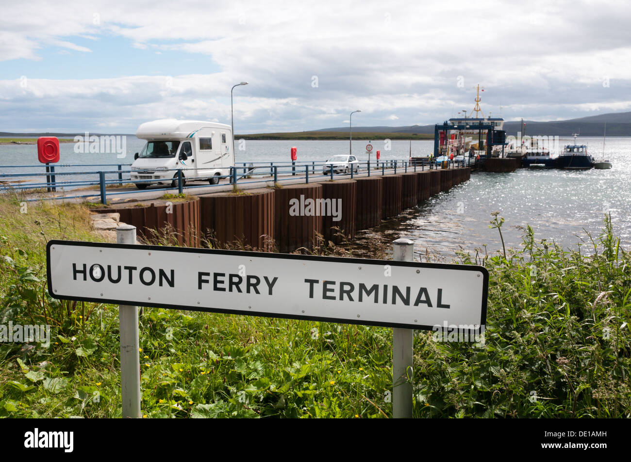 Signe pour Houton Terminal de Ferry sur l'Orkney continent avec les véhicules, y compris un camping-car, laissant Ferry en arrière-plan. Banque D'Images
