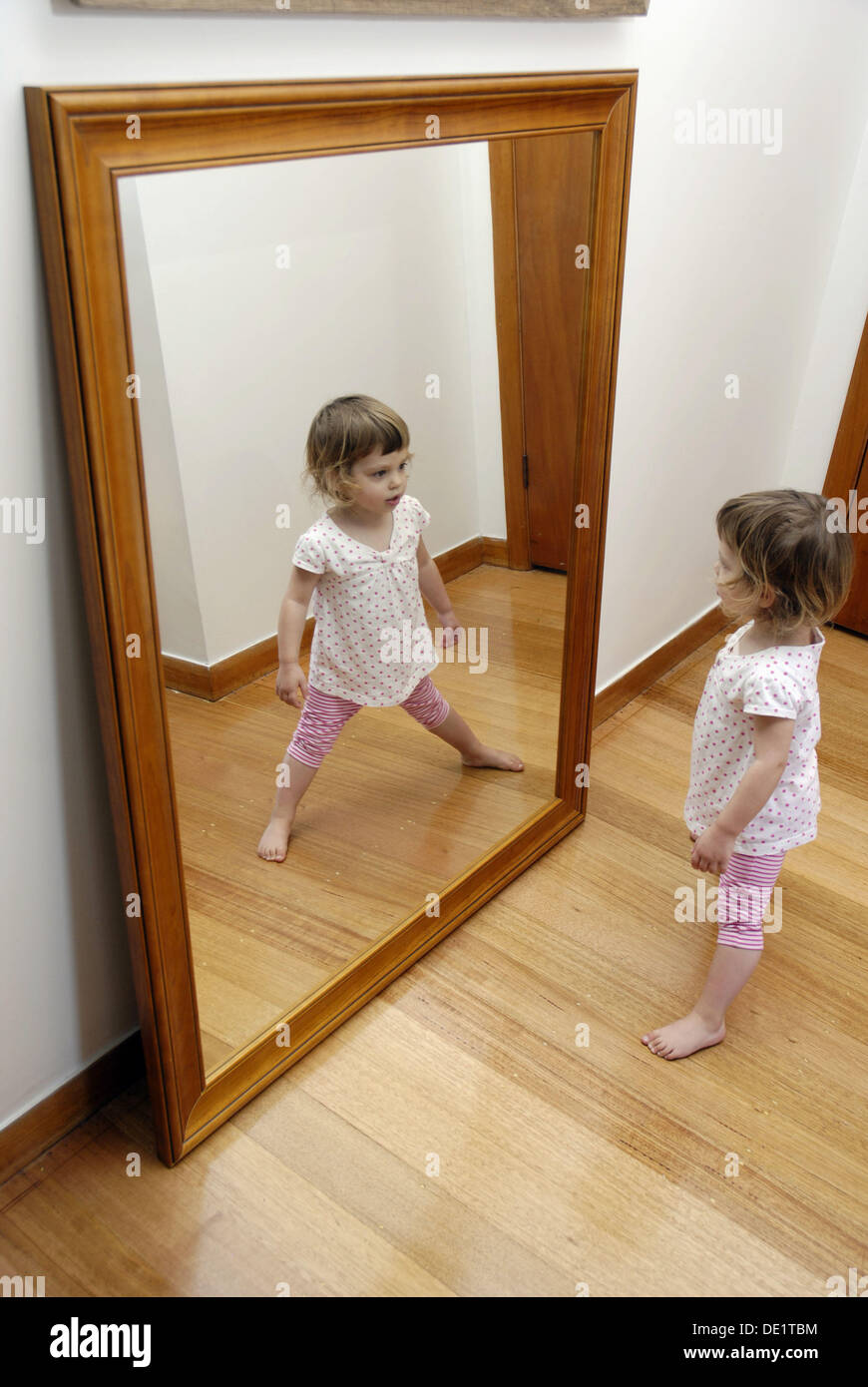 Une jeune fille, âgée de deux ans et demi, jouer en face d'un grand miroir  Photo Stock - Alamy