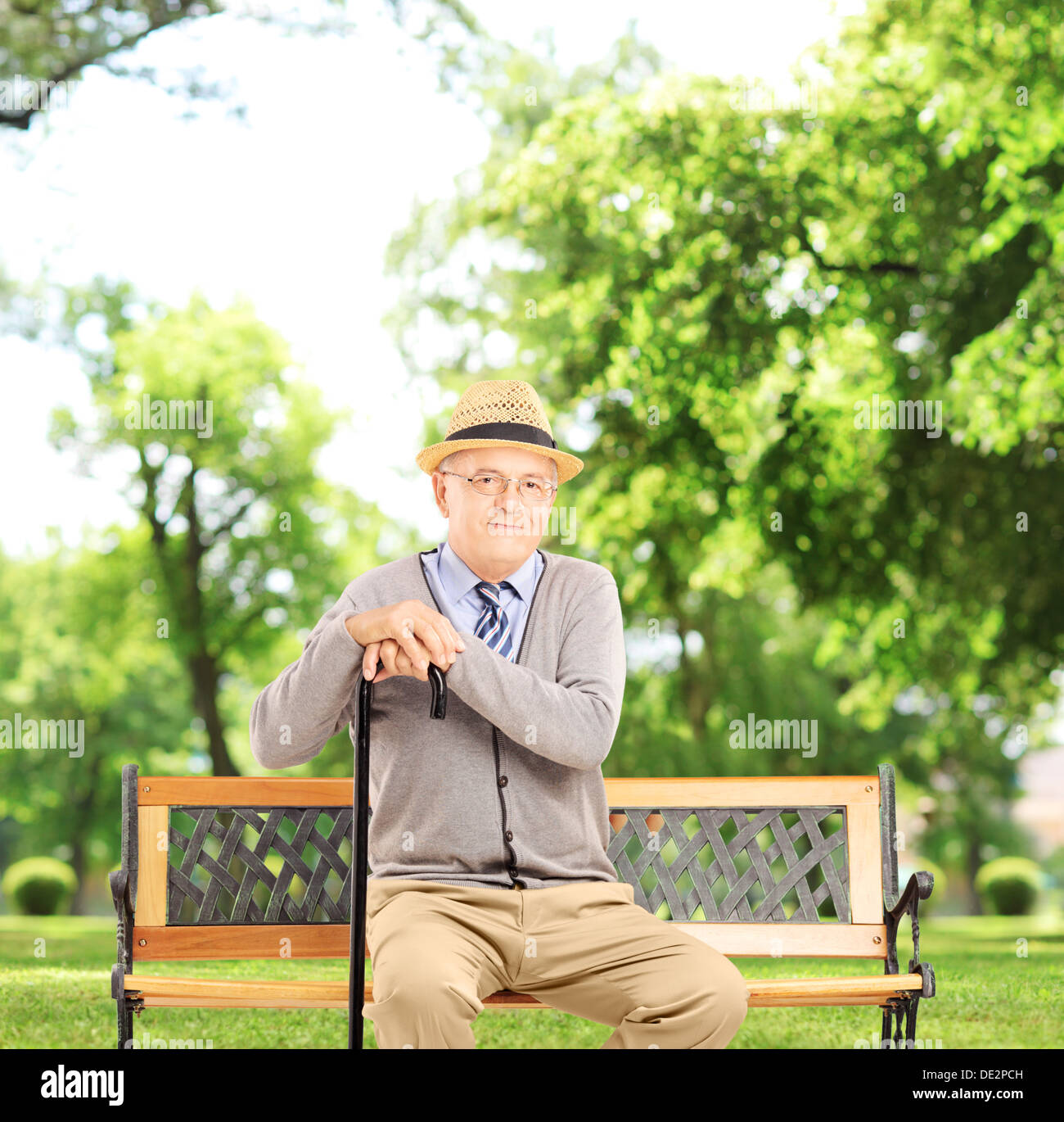 Hauts homme assis sur un banc en bois et, dans un parc Banque D'Images