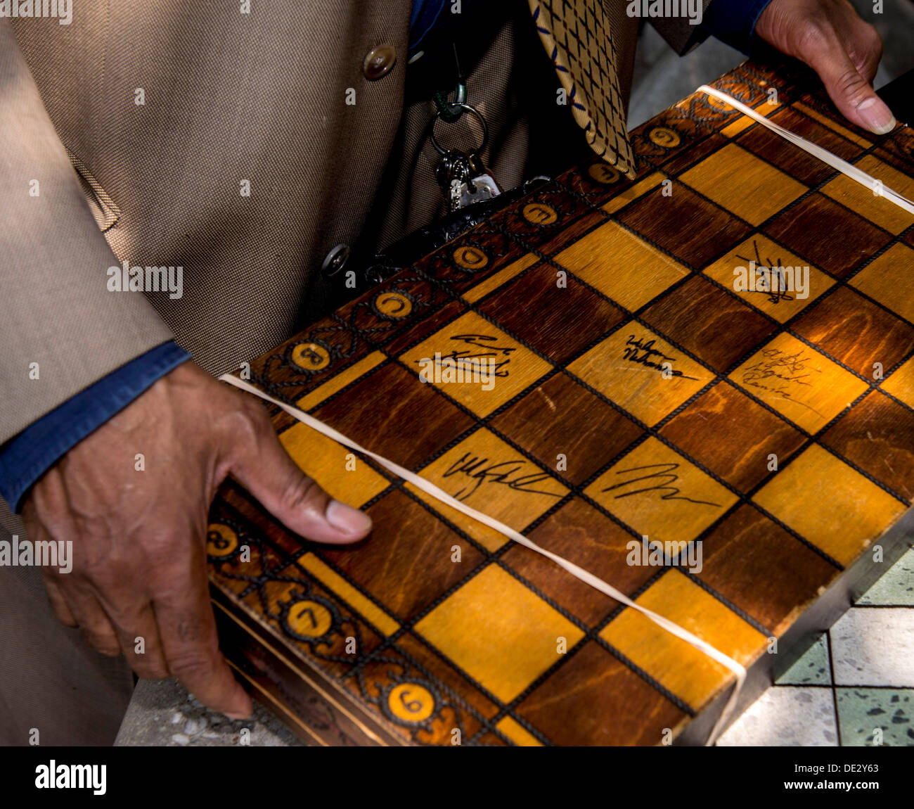 Saint Louis, Missouri, USA. 10e Août, 2013. Un ventilateur d'échecs est titulaire d'un jeu d'échec avec des autographes de grandmasters lors de la deuxième journée de la première tasse Sinquefield tenue au Club d'échecs scolaires et centre de Saint Louis. Le tournoi de quatre hommes comprend les deux meilleurs joueurs au monde, Magnus Carlsen (FIDE rating : 2862) et LEVON ARONIAN (FIDE rating : 2802), et les deux meilleurs joueurs aux États-Unis HIKARU NAKAMURA (FIDE rating : 2774) et GATA KAMSKY (FIDE rating : 2733). . © Brian Cahn/ZUMAPRESS. Credit : ZUMA Press, Inc./Alamy Live News Banque D'Images